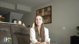 A mature woman shares a couch with her stepson in a steamy scene