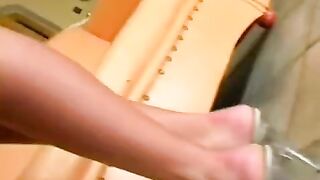 Beauty caresses herself in a leather chair, reaching intense pleasure