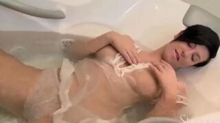 A lonely brunette woman caresses her wet pussy under the shower head