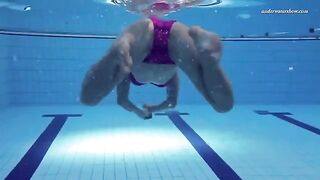 A hot naked girl is swimming in the pool with a lot of water