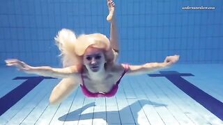 A hot naked girl is swimming in the pool with a lot of water