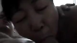 An experienced Chinese woman teaches her guy how to perform a blowjob