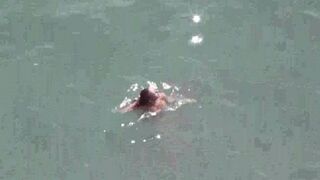 A pair of naked lovers have fun on the sea