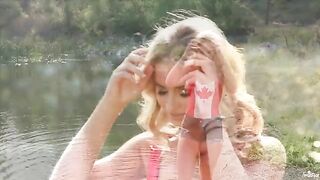 A blonde is indulging herself on the banks of a lake