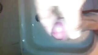 The kid caresses his dick under the water pressure in the shower