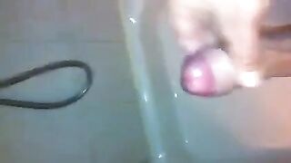 The kid caresses his dick under the water pressure in the shower