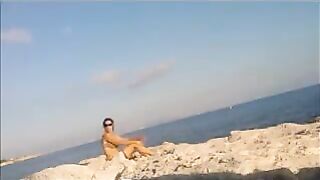 A young girl is basking in the sun completely naked on the beach