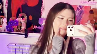 The girl plays with a big dildo in front of the mirror, showcasing her alternative style